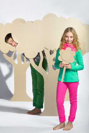 Love concept. Couple of kids. boy gives a girl cardboard flowers.の写真素材