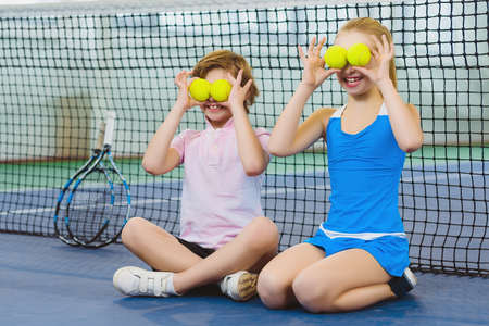 children having fun and playing on the tennis court.の写真素材