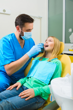 Little girl sitting in the dentists office.の写真素材