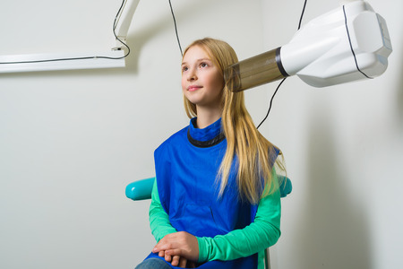 Dentist hands make jaw x-ray image for little girl in dental clinic.の写真素材