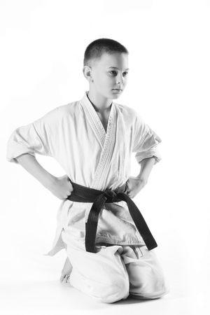 boy in white kimono during training karate exercises on a white background.の写真素材