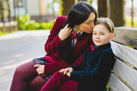 trendy mother kissing her stylish son outdoor.の写真素材