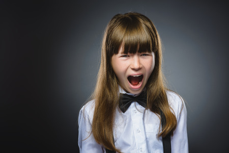 Closeup Portrait of handsome girl with astonished expression while standing against grey background.の写真素材