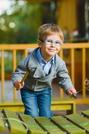 Close up portrait of cute boy playing xylophone outdoor.の写真素材