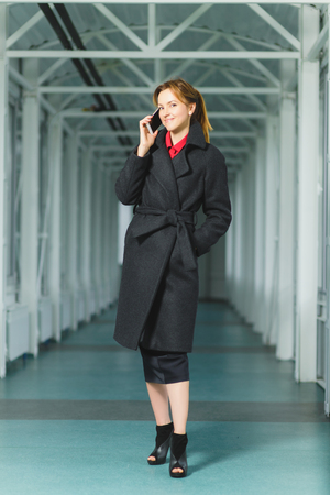 fashion elegant woman dressed coat stand in lobbyの写真素材