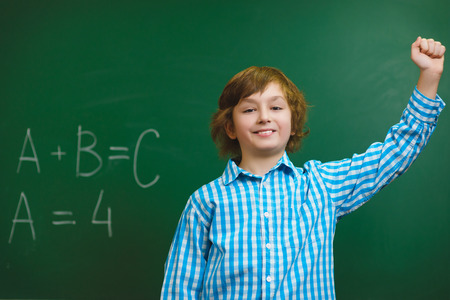 Happy smiling boy on blackboard background . Educational and school conceptの写真素材