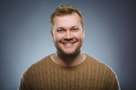 Happy man. Portrait of handsome man smiling isolated on grey backgroundの写真素材