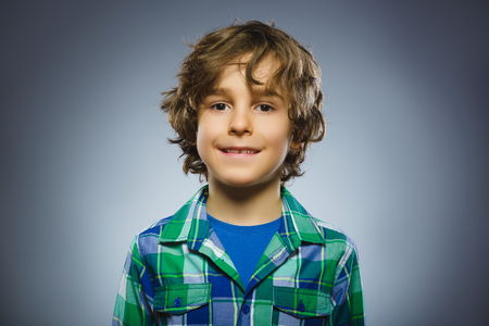 Happy child. Portrait of handsome boy smiling isolated on grey backgroundの写真素材