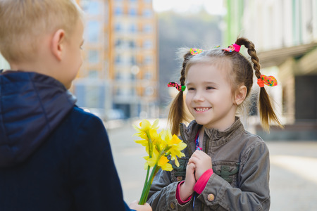 the little gentleman gives the girl a bunch of flowersの写真素材