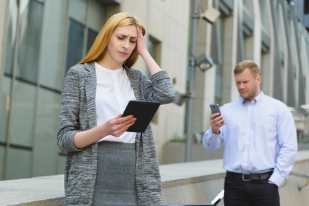 Two discontented unhappy young business people taking online meeting outdoorの写真素材