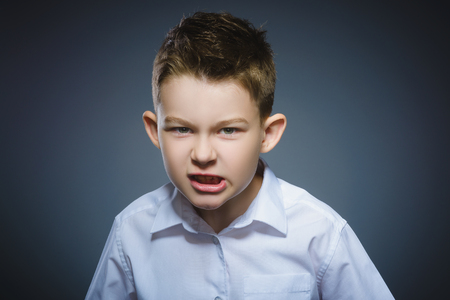 angry boy isolated on gray background. Closeupの写真素材