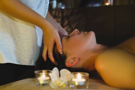 Massage therapist massaging beautiful brunetteの写真素材