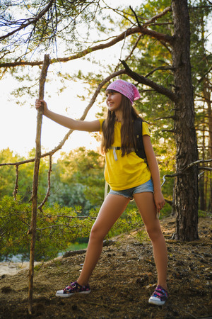 Girl traveler with backpack in hill forest. Adventure, travel, tourism conceptの写真素材