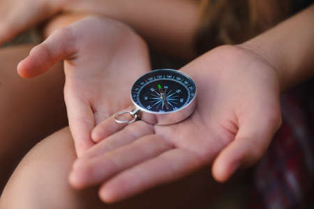 Compass in the teenagers hands. Adventure, travel, tourism conceptの写真素材