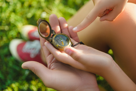 Man and girl with backpack resting and looking at compassの写真素材