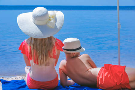 children on the beach relax in the summer on vacation looking into the distanceの写真素材