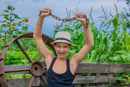 Summer boy in a child hat in nature happy on nature in the village