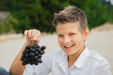 Boy beautiful in nature there are grapes in summer and autumnの写真素材