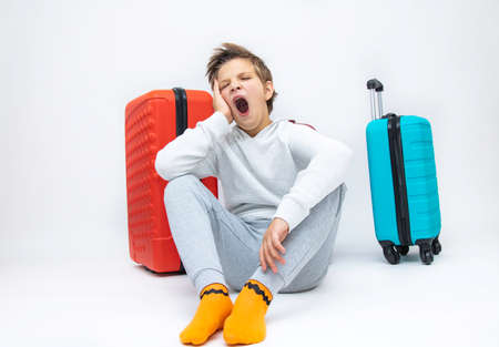 Traveling with a suitcase, happy child on vacation, white background, close-up.の写真素材