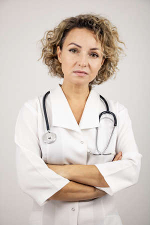 Girl doctor in a white coat with a stethoscope, close-up on a white background.の写真素材