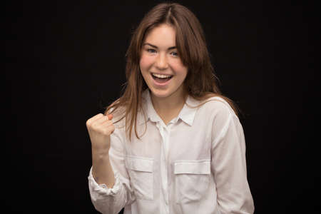 girl close-up, on a dark background shows emotions delight, happiness,
