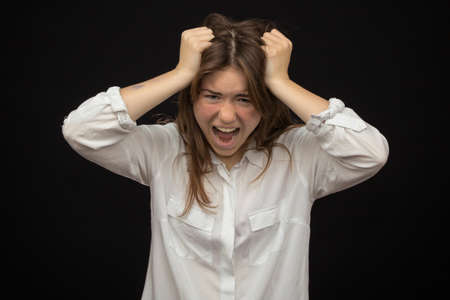 girl close-up, on a dark background shows emotions of irritation, anger.