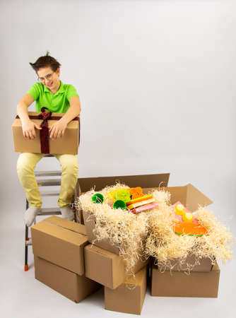 a boy looks at a lot of cardboard boxes brought from a warehouse storeの写真素材