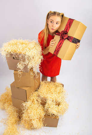 the girl is very happy and delighted with the box with giftsの写真素材