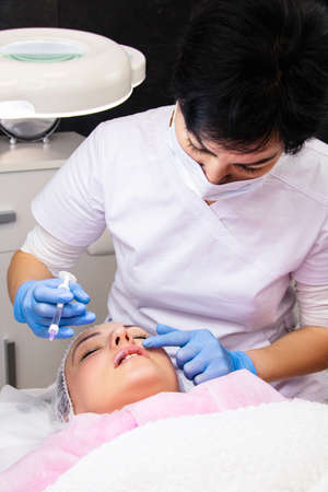 Cosmetology, lip augmentation, beauty injections in a beauty salon, close upの写真素材