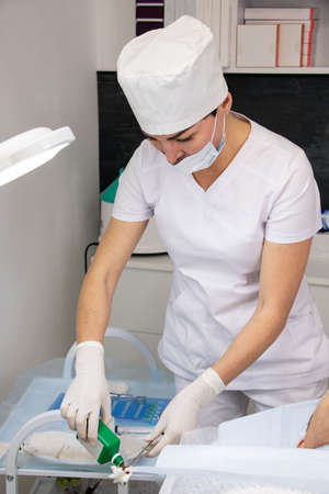 Girl beautician prepares for a cosmetic procedure for a man, in a beauty salon, prepares drugs