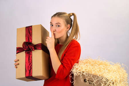 the girl is very happy and delighted with the box with gifts