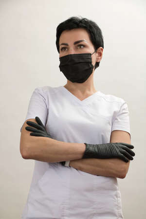Girl doctor in mask and gloves gesturing with her handsの写真素材
