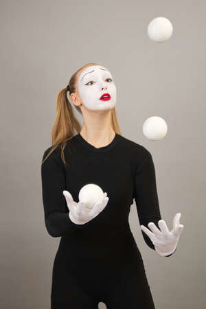 The mime artist juggles balls. Circus clown woman.の写真素材