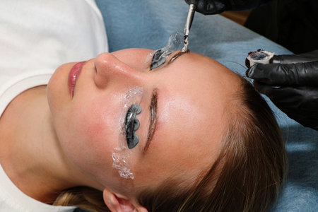 Eyebrow and eyelash tinting in a beauty salon. Face close-up.