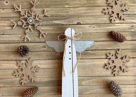 Holiday Christmas wooden angel with snowflakes and pineconesの写真素材