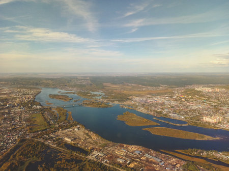 Aerial panoramic view of Irkutsk city and the Angara River in Siberia, Russia. The photograph was taken from an airplane window during descent, showing urban structures, bridgesの写真素材