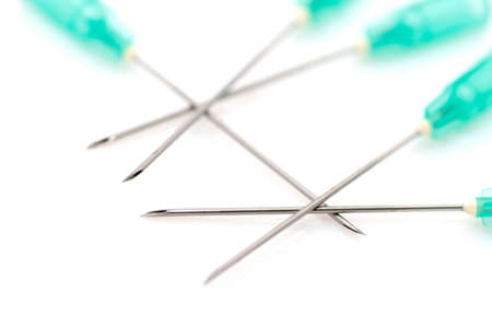 Crossed syringe needles on white backgroundの写真素材