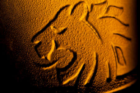 Mist on lion's silhouette on beer bottle in opposite lightの写真素材