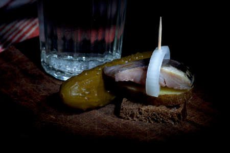 Sandwich made of herring on boiled jacket potato and rye bread served with vodkaの写真素材