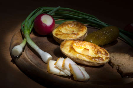 Baked potatoes in their jacket served with salted lard and green onionの写真素材