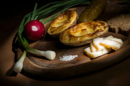 Baked potatoes in their jacket served with salted lard and green onionの写真素材