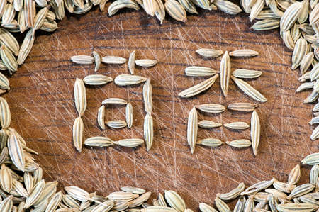 Fennel written in Chinese characters with fennel seeds on wood close upの写真素材