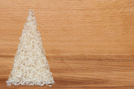 Christmas tree made of rice grains on cutting boardの写真素材