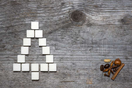 Christmas tree greeting card made of lump sugar and spices on wooden background