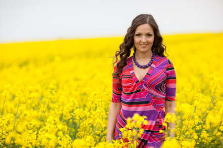 Vibrant yellow canola field and cheerful girl, spring feeling from Latvia, Baltic statesの写真素材