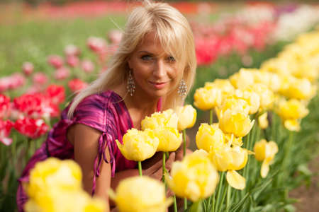 Beautiful blond  girl with tulip flowers, amazing spring photo from Latvia, Baltic states, Europeの写真素材