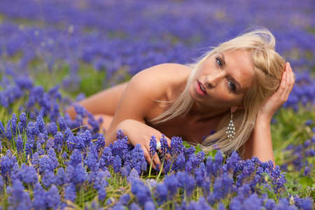 Beautiful blond  girl with violet spring flowers の写真素材