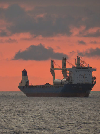 Cargo ship in the sea at sunset.