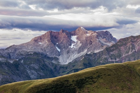 Purple light illuminates a big mountain and the moody skyの写真素材