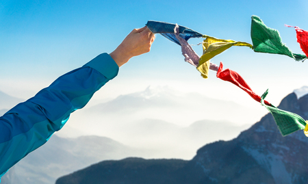 Female hand holds colored flags. Happy success reaching mountain summit.の写真素材